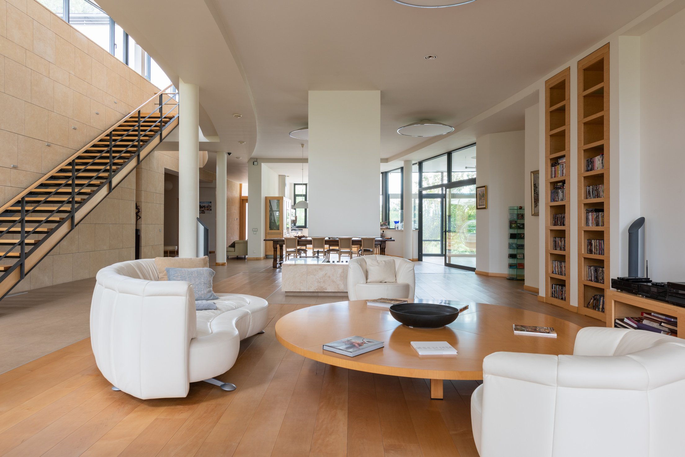 Spacious apartment with bookshelves and round shaped wooden table